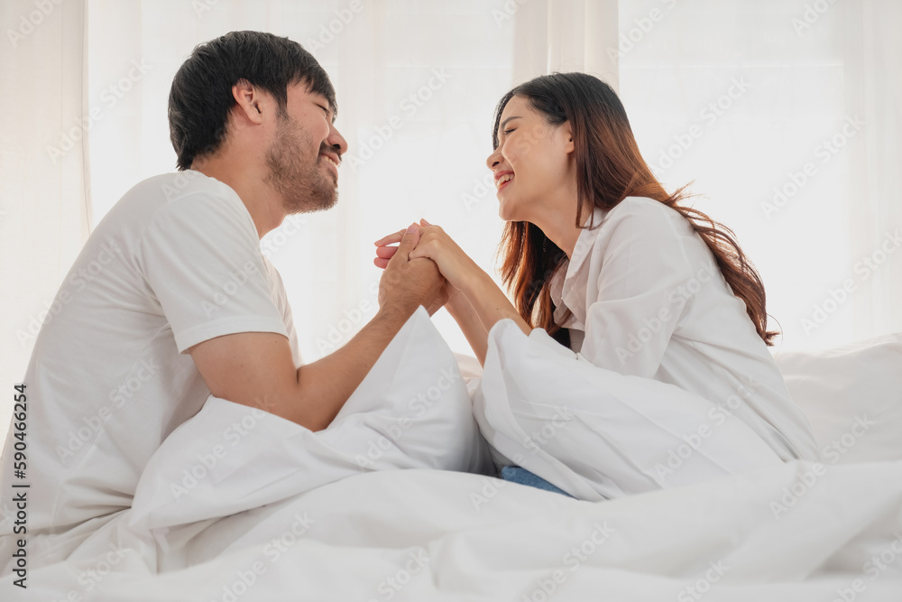 Happy young asian couple embracing, teasing, playing cheerfully in bed at home, romantic time to enhance family bonding. family concept. Happy young asian couple embracing, teasing, playing cheerfully in bed at home, romantic time to enhance family bonding. family concept.