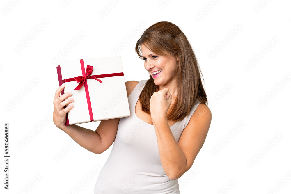 Middle age caucasian woman holding a gift over isolated background celebrating a victory Middle age caucasian woman holding a gift over isolated background celebrating a victory