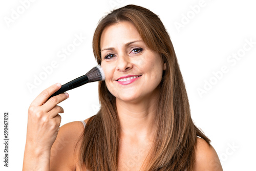 Middle age woman over isolated background holding makeup brush and whit happy expression