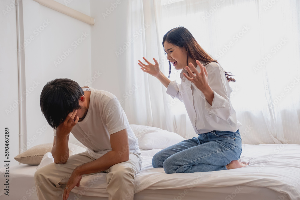 Internal violence. family conflict A woman is violently reprimanding her husband in an angry mood. make the husband feel bad In the bed inside the house, family quarrel concept. Internal violence. family conflict A woman is violently reprimanding her husband in an angry mood. make the husband feel bad In the bed inside the house, family quarrel concept.