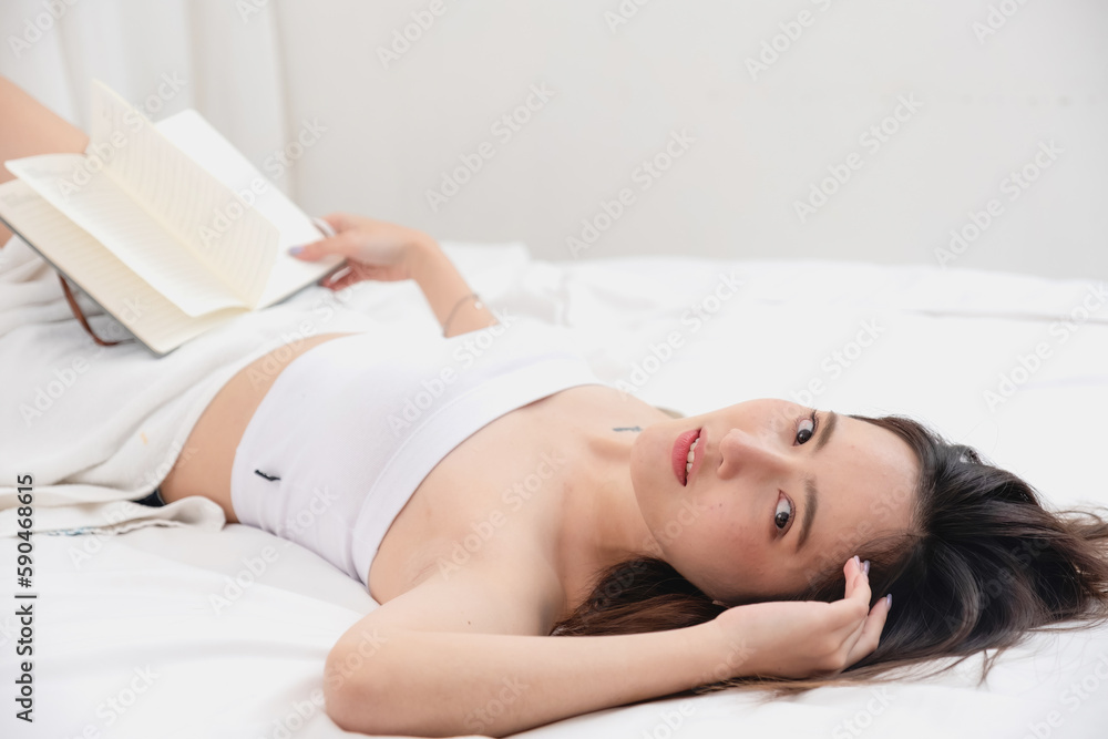 Portrait of white Asian woman with tattoo resting in bed to rest and relax inside white bedroom on her holiday, holiday morning concept. Portrait of white Asian woman with tattoo resting in bed to rest and relax inside white bedroom on her holiday, holiday morning concept.