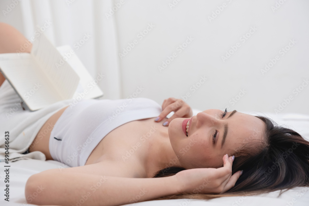 Portrait of white Asian woman with tattoo resting in bed to rest and relax inside white bedroom on her holiday, holiday morning concept. Portrait of white Asian woman with tattoo resting in bed to rest and relax inside white bedroom on her holiday, holiday morning concept.