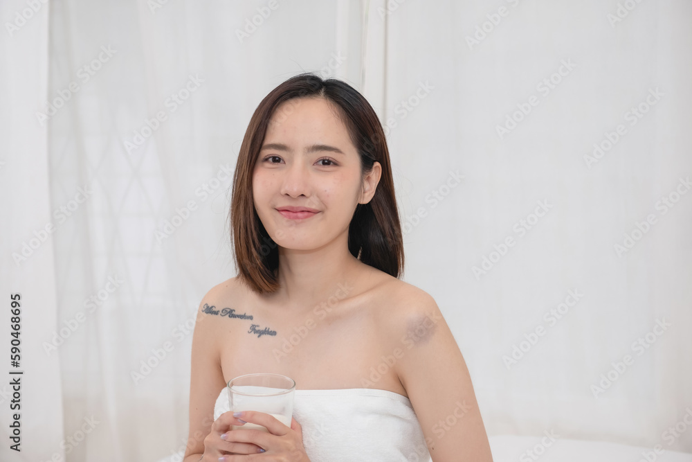Portrait of young cheerful Asian woman drinking healthy milk on the morning of the holiday Good rest and healthy lifestyle concept. Portrait of young cheerful Asian woman drinking healthy milk on the morning of the holiday Good rest and healthy lifestyle concept.