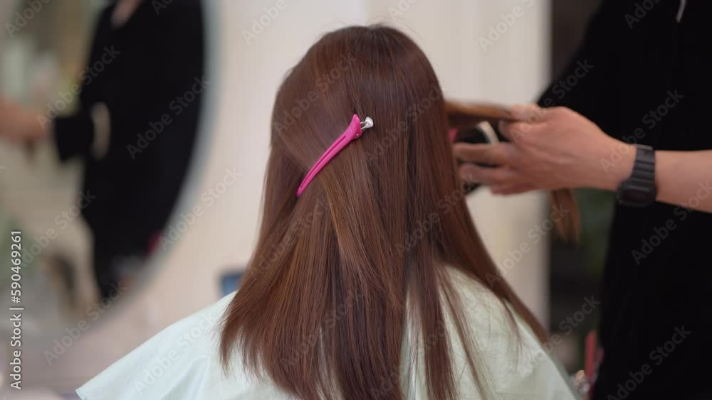 女性の髪を切る男性美容師