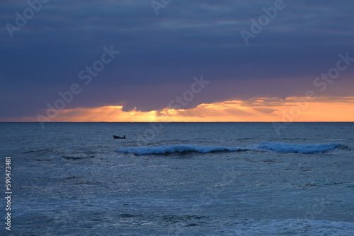 God rays shining through clouds over the ocean early in the morning. 