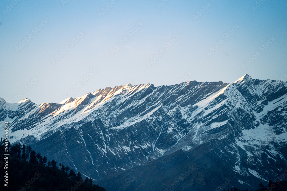 rocky himalayan peaks with snow covering the top against the blue sky showing the beauty of leh ladakh spiti valley