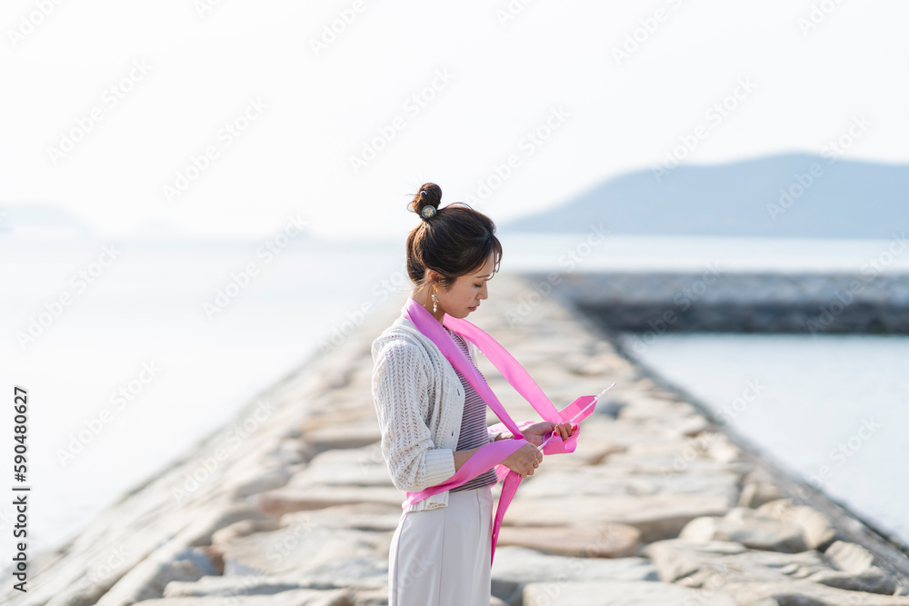 海でリボンを扱う女性