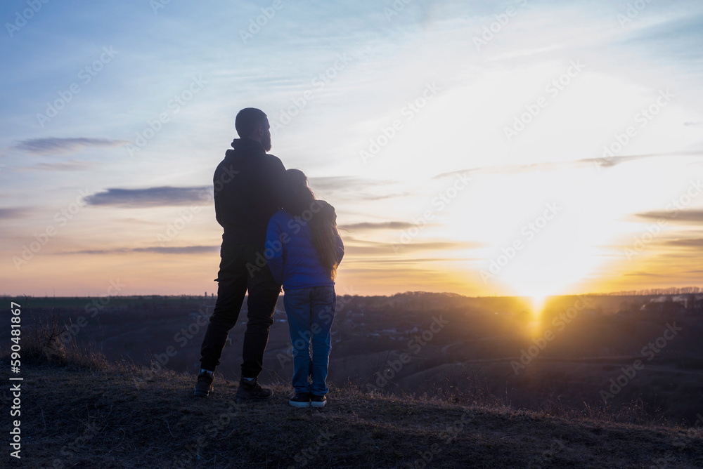 Dad and daughter. Against the background of the sunset and mountains. father's day Dad hugs the children. Family Dad and daughter. Against the background of the sunset and mountains. father's day Dad hugs the children. Family