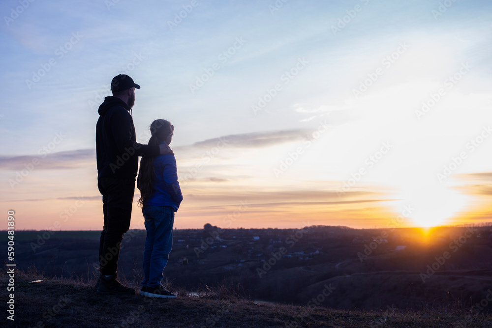 Dad and daughter. Against the background of the sunset and mountains. father's day Dad hugs the children. Family Dad and daughter. Against the background of the sunset and mountains. father's day Dad hugs the children. Family