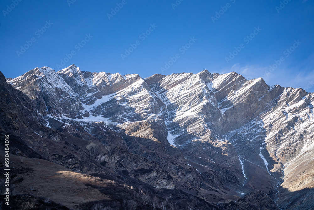 rocky himalayan peaks with snow covering the top against the blue sky showing the beauty of leh ladakh spiti valley