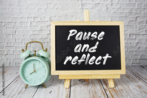 фотографія Pause and Reflect text message write on blackboard with alarm clock on wooden ba