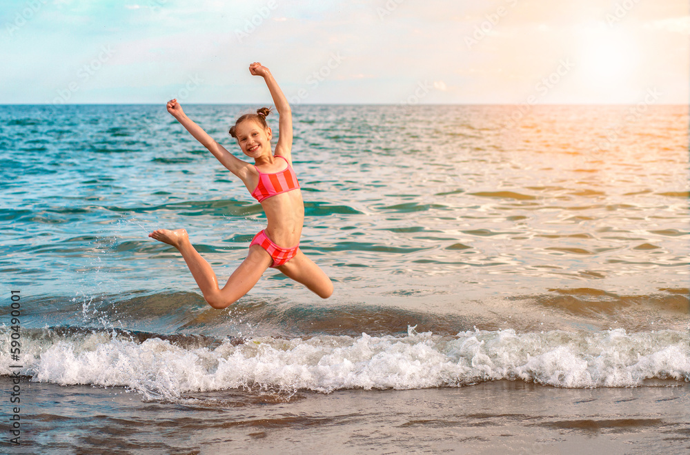 Having Fun in Sea Holiday. Happy Little Girl Kid jumping in Sea Waves  on Sunny Day. Copy space.