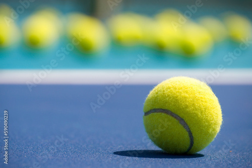  tennis balls on hard blue court