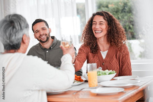 Family dinner, couple and cheers of a happy woman with healthy food in a home. Celebration, together and people with unity from eating at table with happiness and a smile in a house with toast