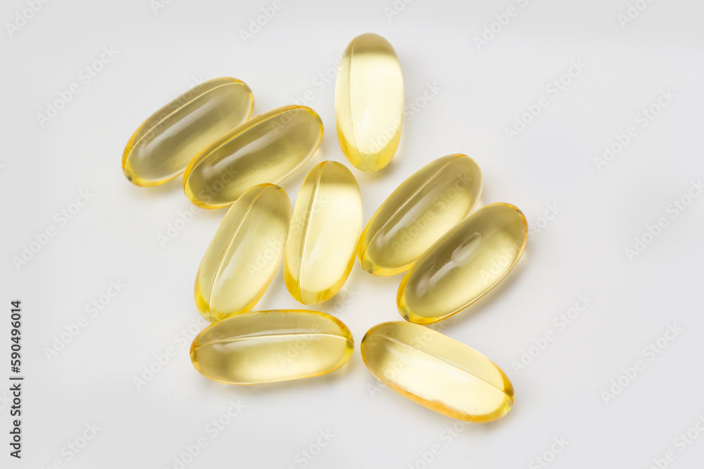 Fish oil capsules omega 3 on light background. Transparent yellow capsules of fish oil Fish oil capsules omega 3 on light background. Transparent yellow capsules of fish oil