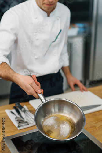 professional kitchen chef caramelizing fruit for oatmeal in a pan preparing breakfast healthy food concept