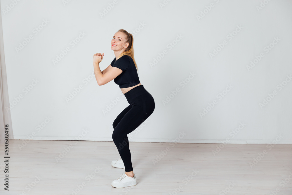 a woman does exercise warm-up exercises in the gym