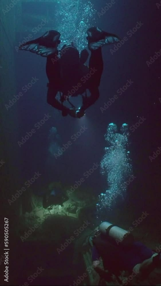 Vertical video, Scuba divers swimming inside hold of ferry Salem Express shipwreck, Slow motion
Vertical video, Scuba divers swimming inside hold of ferry Salem Express shipwreck, Slow motion