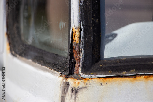 Heavy Rust in the corner of the windshield, on an Oldtimer Camper truck from 1978 before restoration, with multiple bad paint jobs