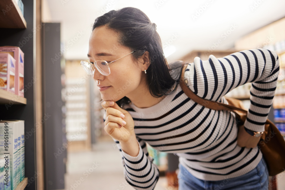 Thinking, woman and choice of shopping at shelf, retail products and reading grocery label of brand information. Female customer, decision and supermarket store for groceries, sales or consumer price Thinking, woman and choice of shopping at shelf, retail products and reading grocery label of brand information. Female customer, decision and supermarket store for groceries, sales or consumer price