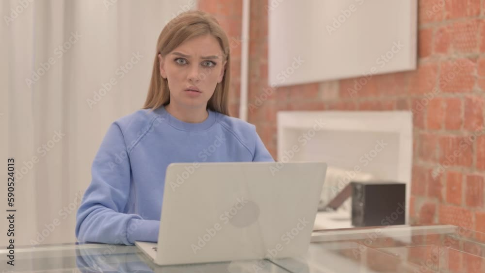 Shocked Young Woman Looking at Camera while Working on Laptop Shocked Young Woman Looking at Camera while Working on Laptop