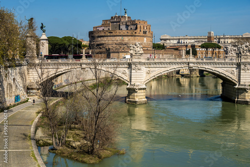Rom, Italien, Apr. 2023 Der Fluß Tiber mit Ponte Principe Amadeo di Savoia, dahinter die Engelsburg und das Gebäude des Cassationsgerichts vor blauem Himmel