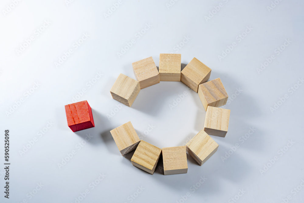 Natural colored wooden cubes, together form a circle with a gap, one red and standing outside, ready to complete the team, light blue gray background, copy space, selected focus
