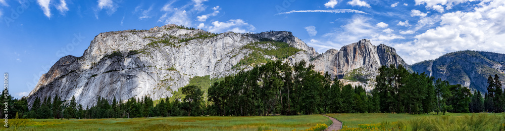 Panorama of Sentinel meadows and rock wall with Columbia Peak and Yosemite Falls in Yosemite National park during the summer.