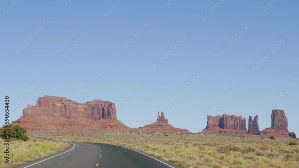 Pov from driving vehicle car on asphalt curved highway with yellow marking going to monument valley background of mountains and rock formation of buttes in western of Usa in desert area. Slow motion Pov from driving vehicle car on asphalt curved highway with yellow marking going to monument valley background of mountains and rock formation of buttes in western of Usa in desert area. Slow motion