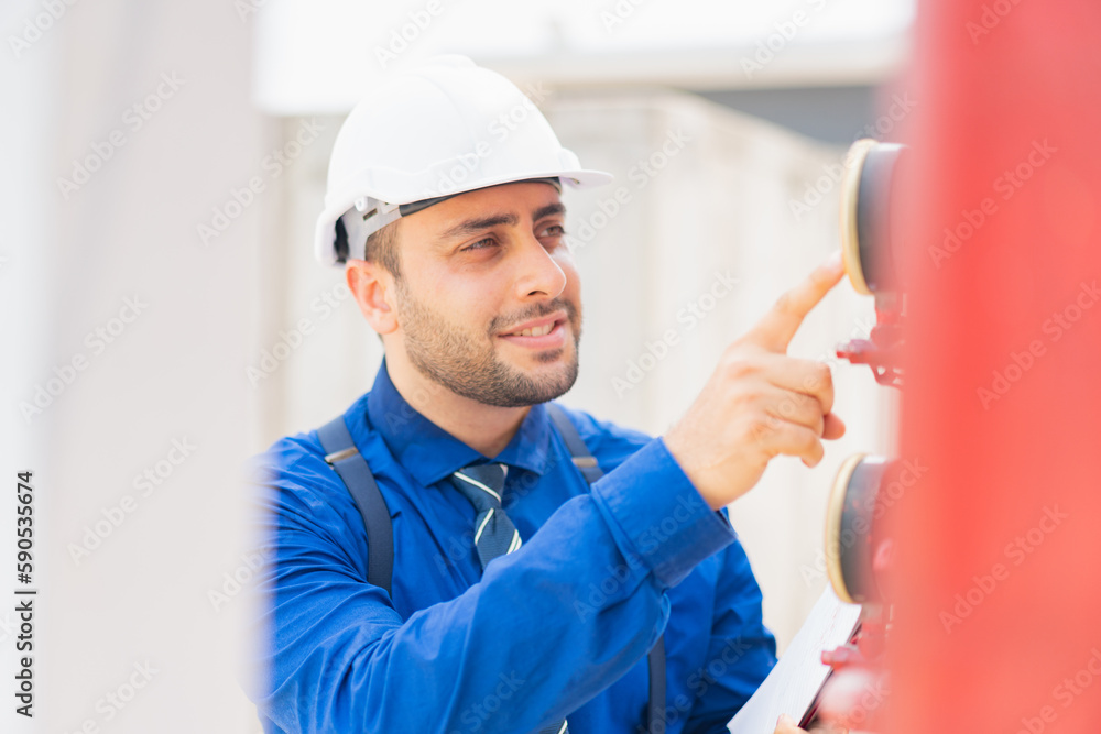 The engineer is inspecting the safety equipment on the fire extinguishing system.The system engineer is checking the pressure and recording it with Clipboard or checking . The engineer is inspecting the safety equipment on the fire extinguishing system.The system engineer is checking the pressure and recording it with Clipboard or checking .