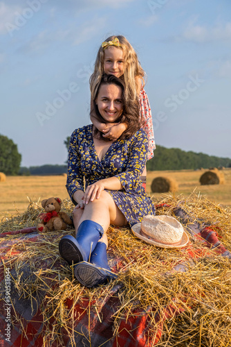 Wallpaper Mural Cute Little Girl Hugging her Mother while Relaxing on the Top of Haystack in Peaceful Summer Evening. Mothers Day Concept  Torontodigital.ca