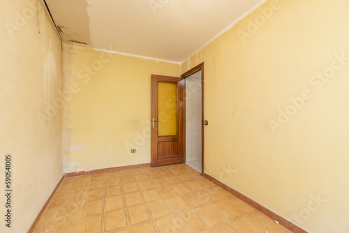 An empty room with poorly painted walls and a sapele wood door with golden glass