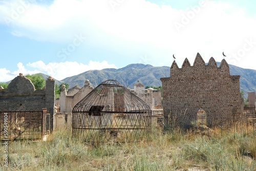 Tian Shan, Kyrgyzstan - circa August 2022: A traditional muslim cemetery at the foot of mountains Tian Shan.