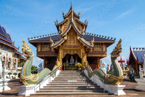 Thai Buddhist temple with blue tiled roof and white statues