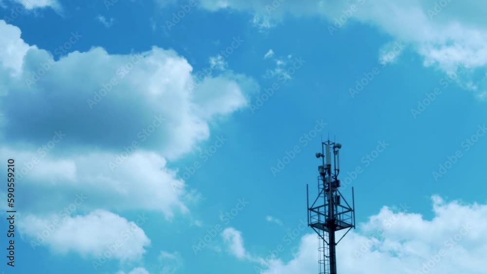 A Cell Tower, A Tower of Mobile Operators for Transmitting a Cellular Signal and Timelapse of Blue Sunny Skies and White Puffy Clouds in Good Weather. A Cell Tower, A Tower of Mobile Operators for Transmitting a Cellular Signal and Timelapse of Blue Sunny Skies and White Puffy Clouds in Good Weather.