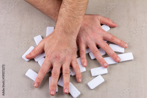Billede på lærred man's hands shuffle inverted white dice of domino board game on gray background