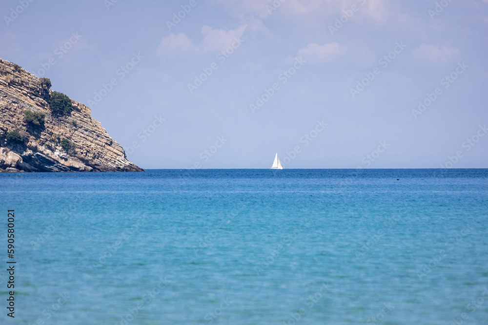 Sailboat on the horizon at the sea in Greece. Copy space