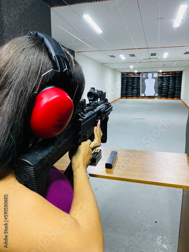 Mulher Atirando no Clube de Tiro / Girl Shooting in the Shooting Club photo