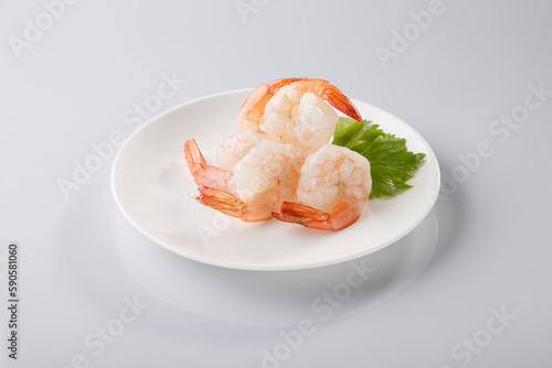 Boiled shrimps in white plate on white background.