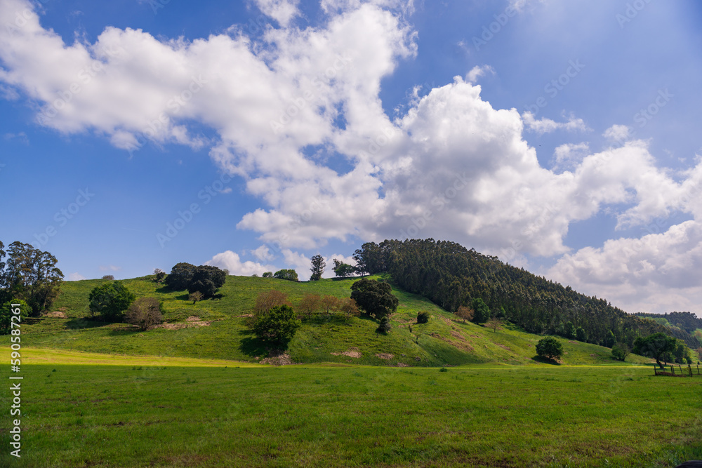 Bright spring landscape with mountains and blue sky and snow-white clouds Bright spring landscape with mountains and blue sky and snow-white clouds