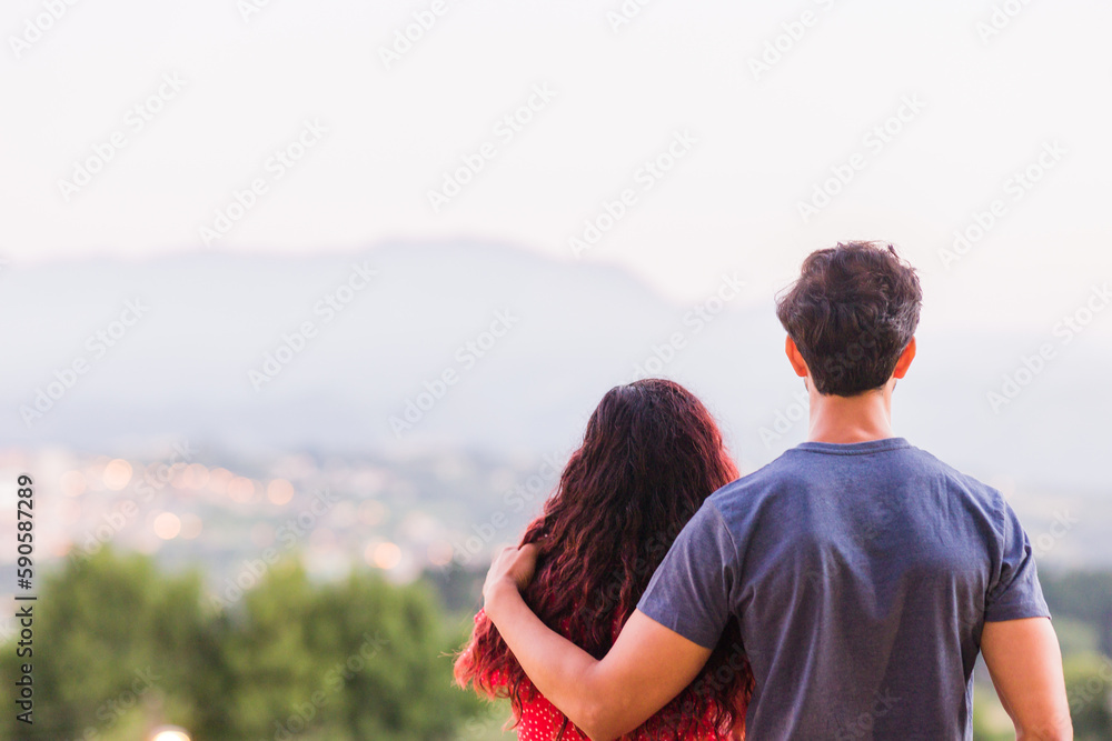 Unrecognizable couple hugging and dream in a future relationship while looking cityscape of Oviedo Unrecognizable couple hugging and dream in a future relationship while looking cityscape of Oviedo