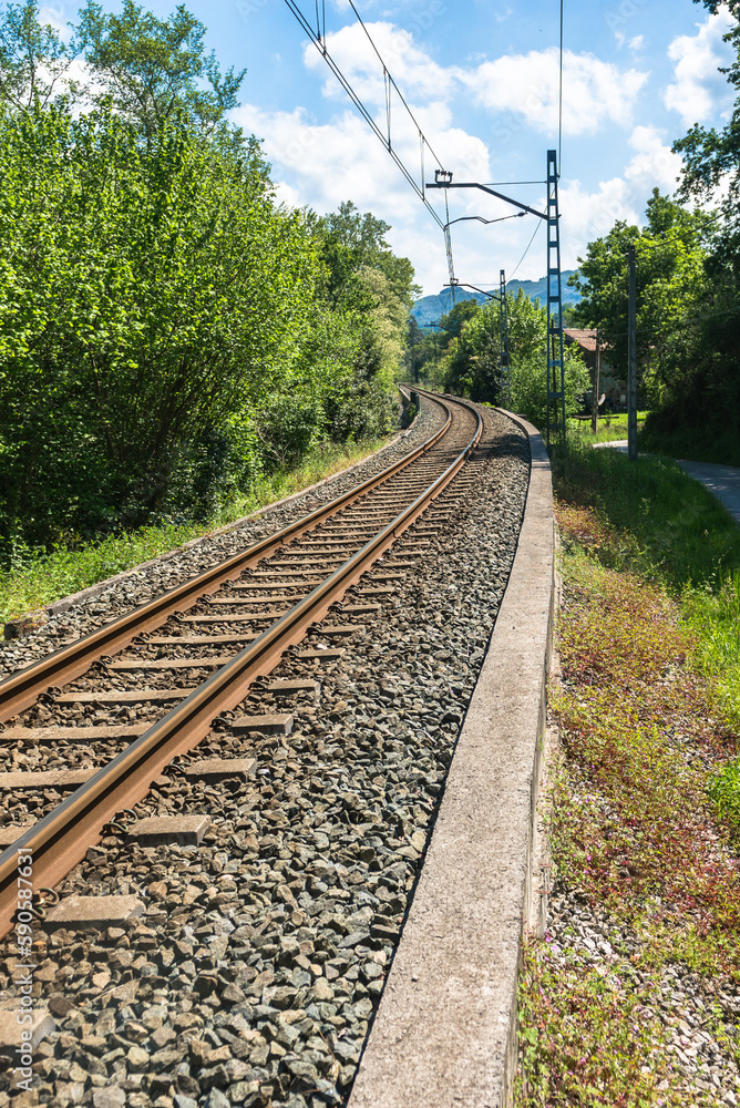 Fototapeta premium The iron rails are covered with rubble. Bright landscape with a railway