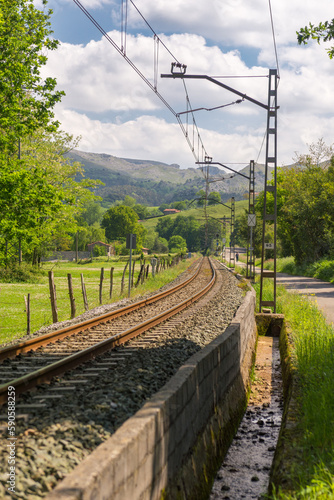 The iron rails are covered with rubble. Bright landscape with a railway
