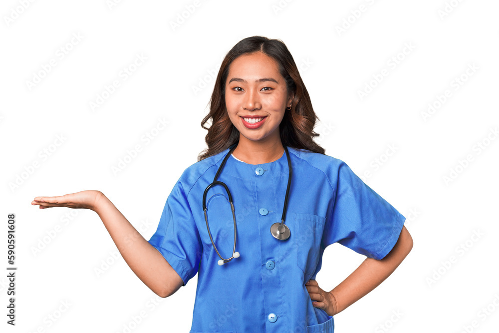 A young nurse chinese woman showing a copy space on a palm and holding another hand on waist. A young nurse chinese woman showing a copy space on a palm and holding another hand on waist.