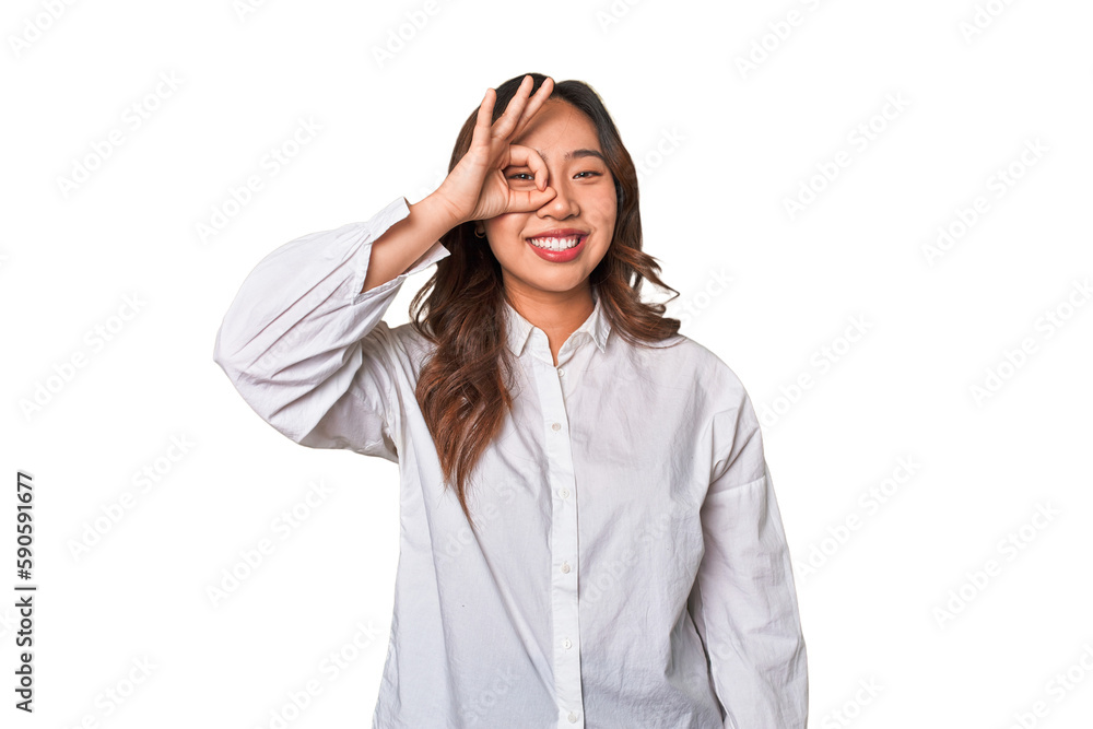 A young chinese woman excited keeping ok gesture on eye. A young chinese woman excited keeping ok gesture on eye.