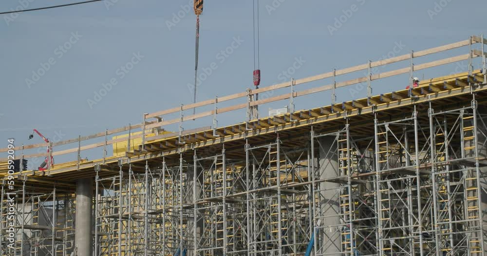 scaffolding and cranes at skyscraper construction site scaffolding and cranes at skyscraper construction site