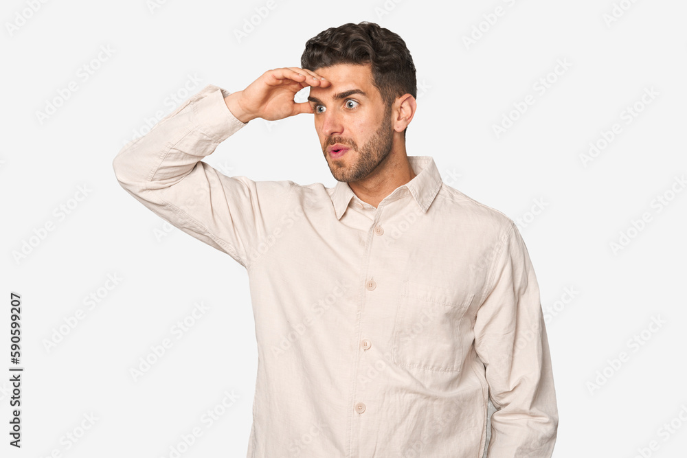 Young handsome man isolated looking far away keeping hand on forehead. Young handsome man isolated looking far away keeping hand on forehead.