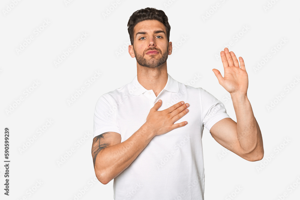 Young handsome man isolated taking an oath, putting hand on chest. Young handsome man isolated taking an oath, putting hand on chest.