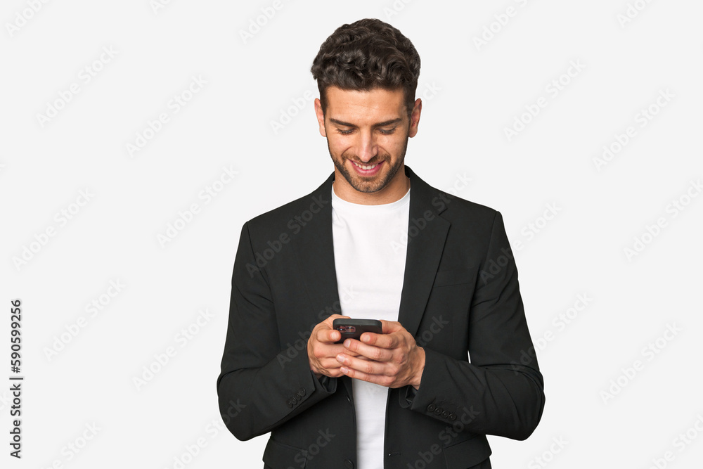 Young businessman sending a cheerful message with modern mobile technology, confident and on-the-go. Young businessman sending a cheerful message with modern mobile technology, confident and on-the-go.