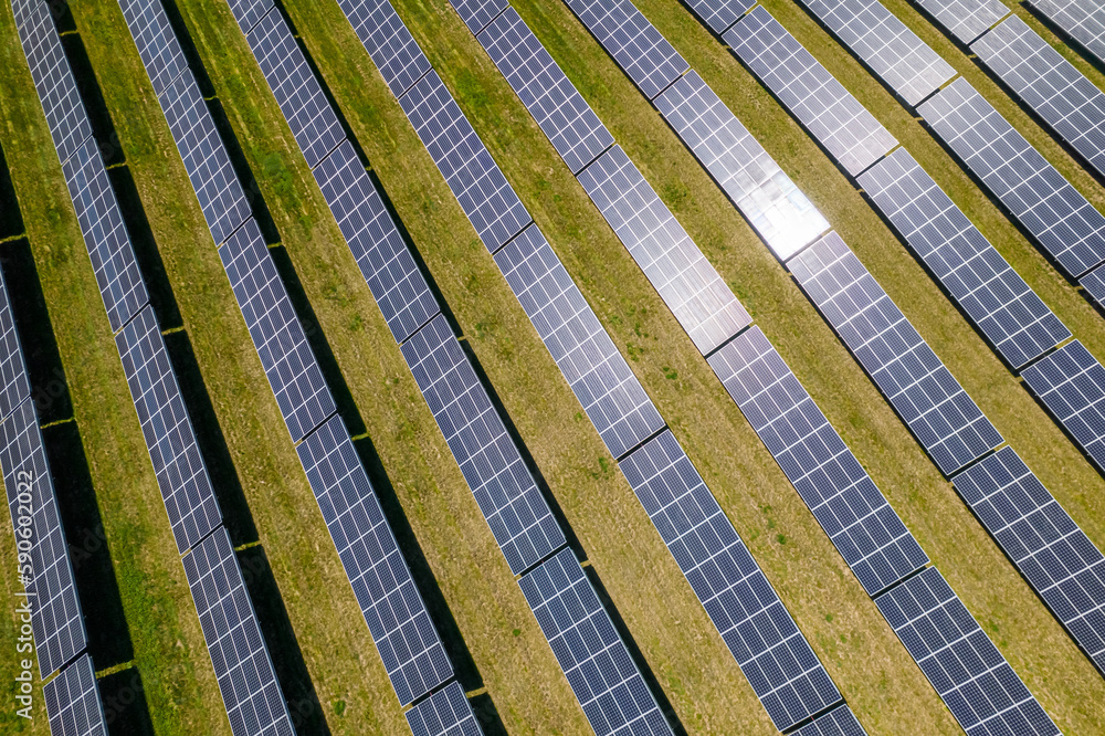 View of modern photovoltaic solar panels to charge battery. Rows of sustainable energy solar panels set up on the farmland. Green energy and environment ecology concept. View of modern photovoltaic solar panels to charge battery. Rows of sustainable energy solar panels set up on the farmland. Green energy and environment ecology concept.